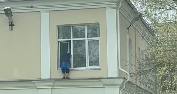 Моющая окно снаружи здания бабушка, озадачила первоуральцев. Видео